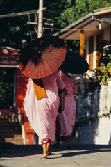 a woman in a pink dress holding an umbrella
