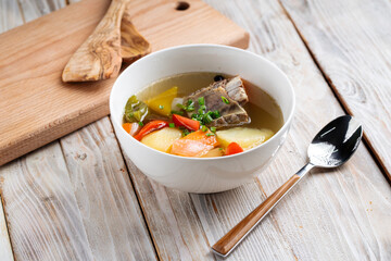 Oriental cuisine shorpa soup with lamb and vegetables in a white bowl
