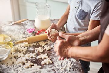 Two people kneading dough and making cookies