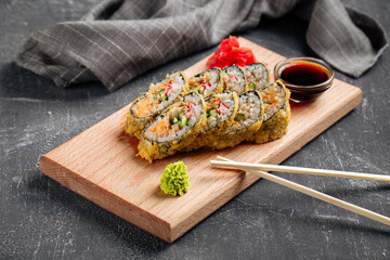 Tempura sushi rolls with cheese and crab meat on the wooden board
