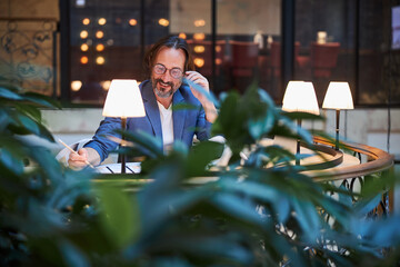 Focused optimistic man doing his work from a comfortable lounge