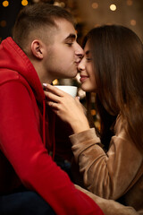 loving couple kissing on the Christmas tree backgroud at home
