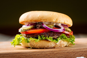 Closeup on classic hamburger with beef patty on the wooden board