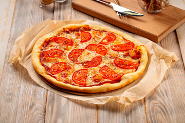 Margherita pizza with tomatoes on the wooden background