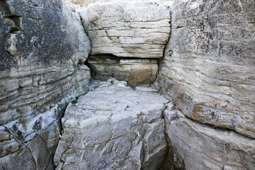 mountain textures of stones with interlayers of gypsum, colored quartz, clay, sand and other layers of various ores, with different textures, color and density, in gypsum ore quarry.