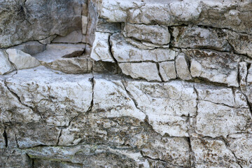 mountain textures of stones with interlayers of gypsum, colored quartz, clay, sand and other layers of various ores, with different textures, color and density, in gypsum ore quarry.