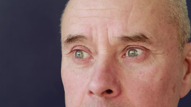 serious elderly man, face with wrinkles, green eyes close up, concept of human memory training, emotions, age problems