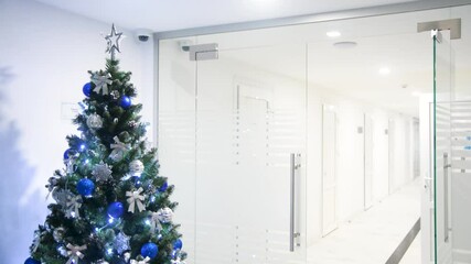 Christmas tree with a garland in the office - Powered by Adobe