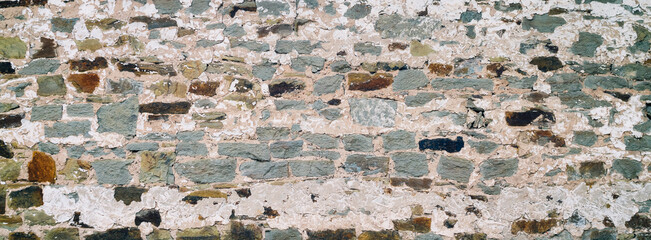 An old wall made of natural stone. Grunge background texture for design.