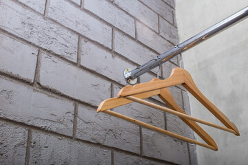 wooden clothes hanger, on a chrome hanger in an empty wardrobe, front and background blurred with...