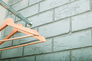 wooden clothes hanger, on a chrome hanger in an empty wardrobe, front and background blurred with bokeh effect