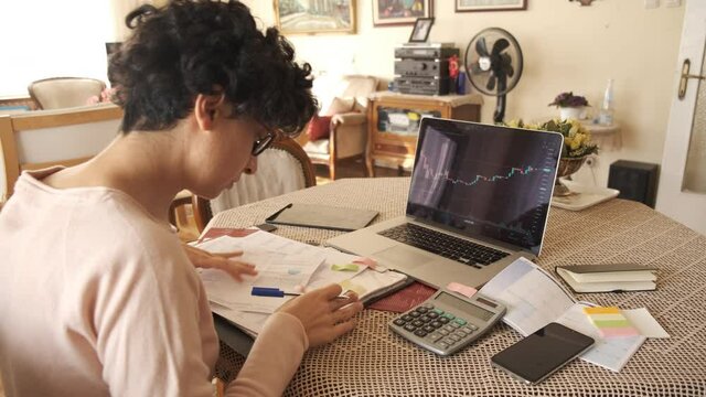 Home office working environment. Using laptop and working efficiently. Using technology and working at home productively. Young female adult study focused.