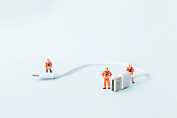 Miniature worker with USB cable, technology industry concept, technology service and phone...