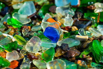 Natural background with sea glass close-up on sand.