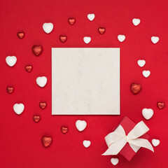 Red white hearts and gift box on red background. Valentines day concept. Flat lay, top view, copy space.
