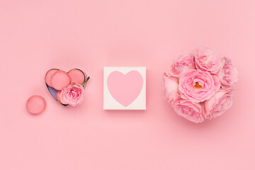Flowers roses, gift box and sweets macaroons on pink background. Valentines day concept. Flat lay,...