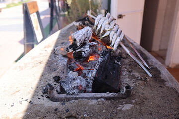 Elaboration of Malaga's espetos al carbón with the beach in the background. Sardines