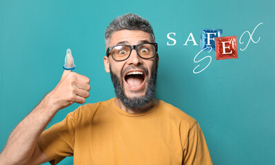 Portrait of happy man with condom showing thumb-up gesture on color background. Concept of safe sex
