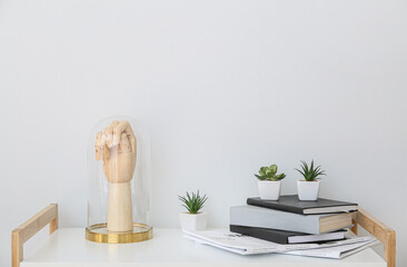 Wooden hand under dome and books on shelving