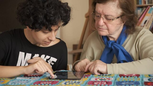 Tablet. Senior adult learning to use digital technology device. Touching screen.