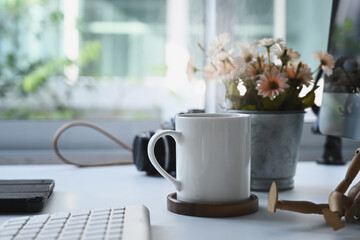 A cup of coffee is putting on photographer workplace at modern home office.