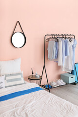 Interior of stylish bedroom with clothes rack