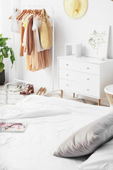 Interior of stylish bedroom with clothes rack