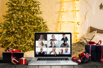 Fototapeta na wymiar Getting together with your loving family is the best gift. Computer with photo of happy parents and children reunited for Christmas set as desktop background standing on desk in cozy room