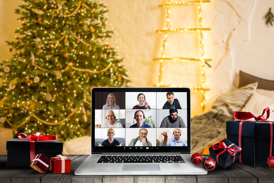 Getting together with your loving family is the best gift. Computer with photo of happy parents and children reunited for Christmas set as desktop background standing on desk in cozy room