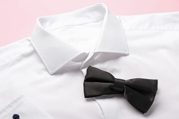 New male shirt and bow tie on color background