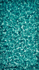 Blue-green vertical wallpaper for a mobile phone. Abstract winter background. Ice crystals on the window pane close up. Dark aquamarine tinted backdrop with vignetting frame