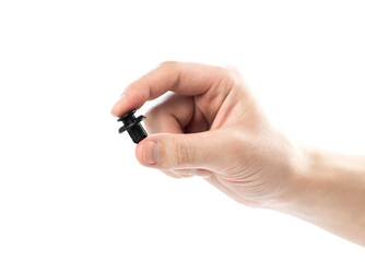 Hand holding black plastic clip for the car. Close up. Isolated on a white background