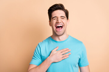 Close-up portrait of attractive cheerful glad guy laughing out loud lol isolated over beige pastel color background