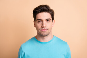 Close-up portrait of attractive content serious well-groomed guy isolated over beige pastel color background