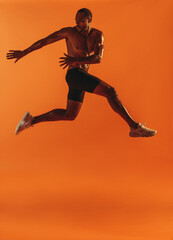 Fit man working out on orange background
