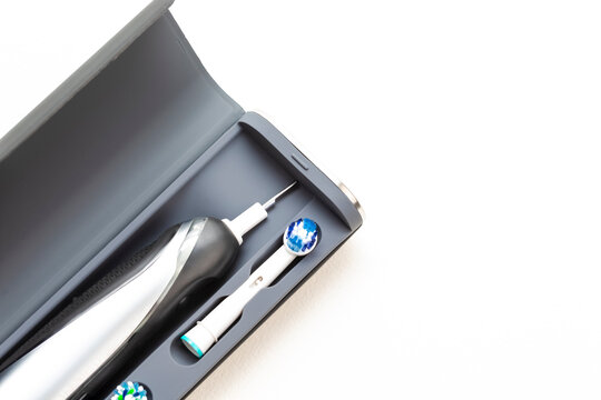 Electric Toothbrush With Spare Attachments in Travel Case on White Background.