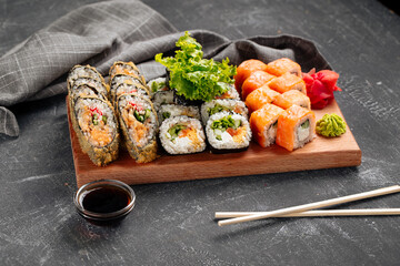 Side view on sushi roll assorted set on the wooden board with soy sauce