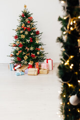 decorated Christmas tree with New Year's gifts in a room with a window