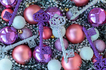 Purple and silver keys on purple and violet Christmas balls. Christmas background. New Year concept.