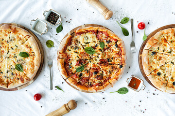 three fragrant pizzas on a white table.