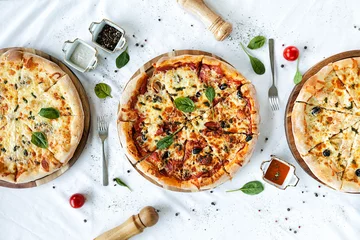 Foto auf Acrylglas three fragrant pizzas on a white table. © lokisurina