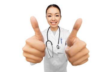 medicine, profession and healthcare concept - happy smiling asian female doctor in white coat with stethoscope showing thumbs up