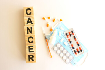 The word CANCER is made of wooden cubes on a white background. Medical concept.