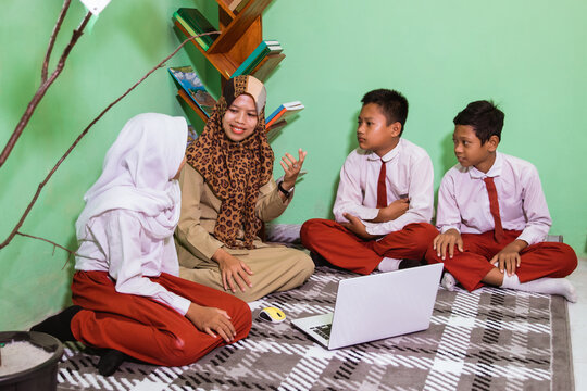 Indonesian school students with their teacher have a discussion in the class