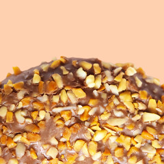 Tasty chocolate donut dessert with glazed and nuts isolated on pink background, top view, copy space. Sweet food concept