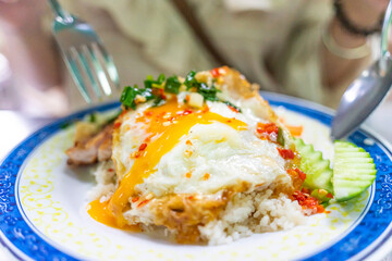 Vietnamese girl eating Com tam - a Vietnamese broken rice with pickles steak grilled pork ribs cucumber onion oil sweet chilies garlic fish sauce fried egg omelet Asian cuisine