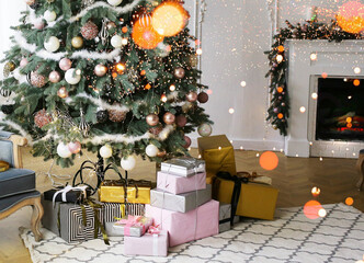 New Year's сhristmas-tree by the fireplace with gifts, balls and lights. Christmas and New Years concept.