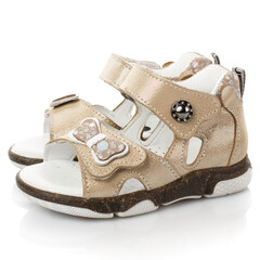 Pair of beige sandals for little girls on white background.