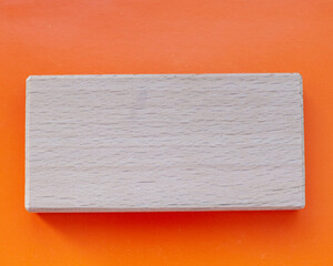 Wooden block on orange background with space for text