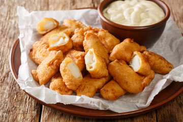 Tasty Kibbeling is a Dutch dish prepared with pieces of cod served with closeup in the plate on the table. Horizontal